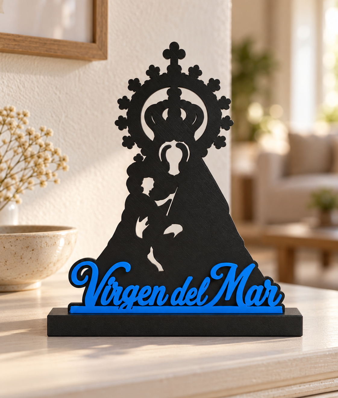 Recreación digital de la Virgen del Mar con letras azules y peana negra sobre una mesa clara